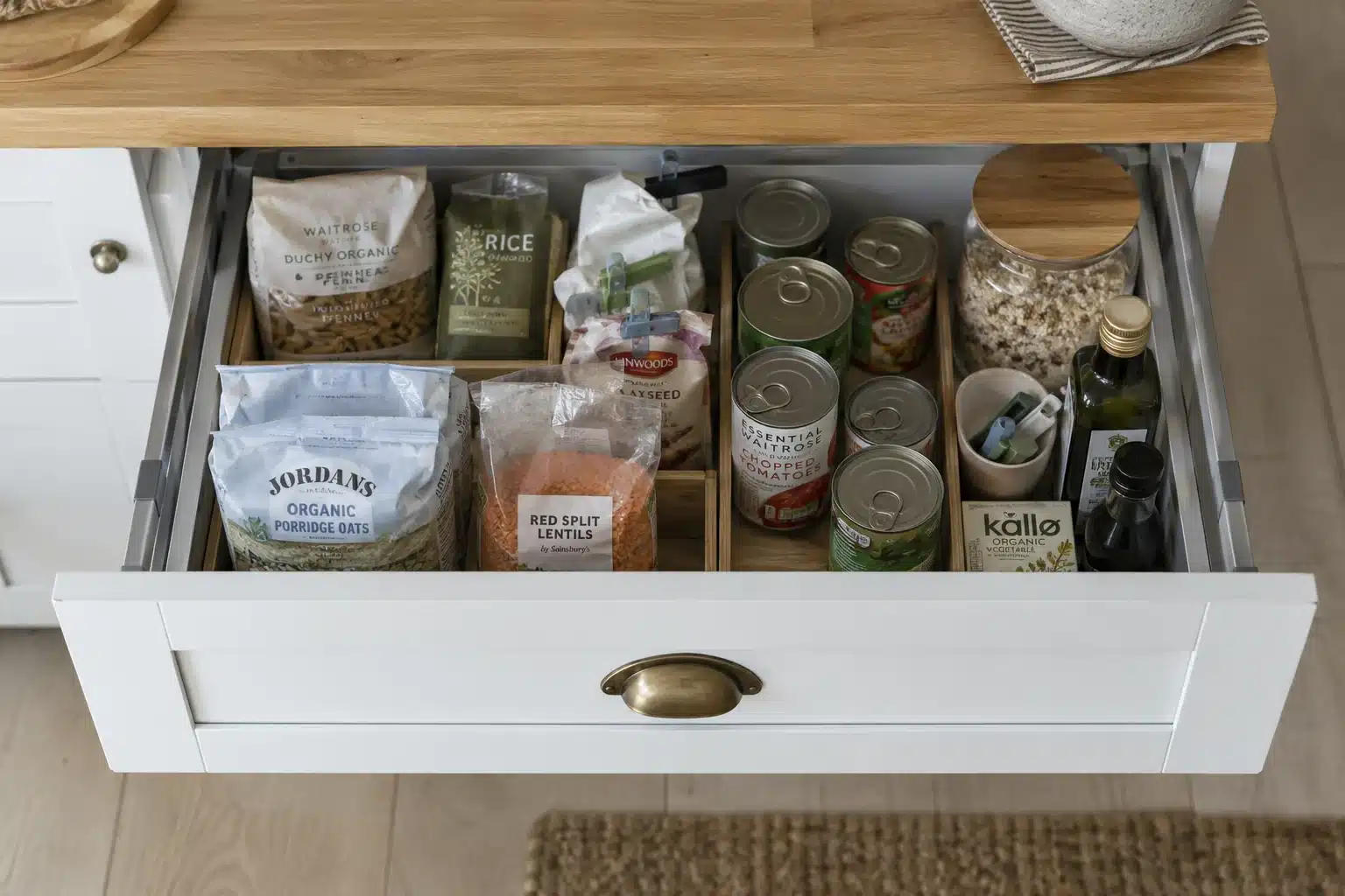 Open lower kitchen drawer with food packets separated by low dividers